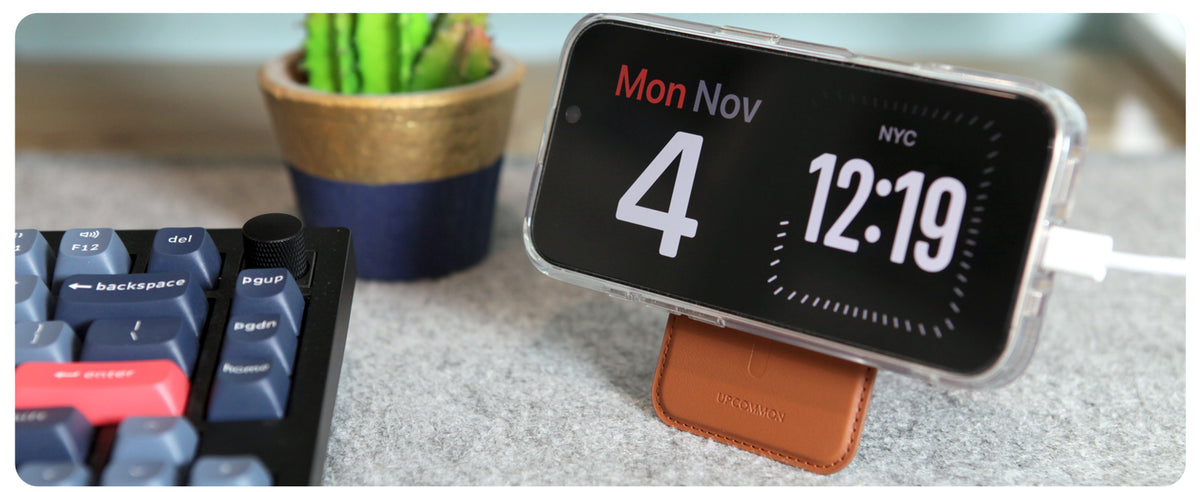 Tan wallet stand holding an iPhone in landscape StandBy mode on a desk