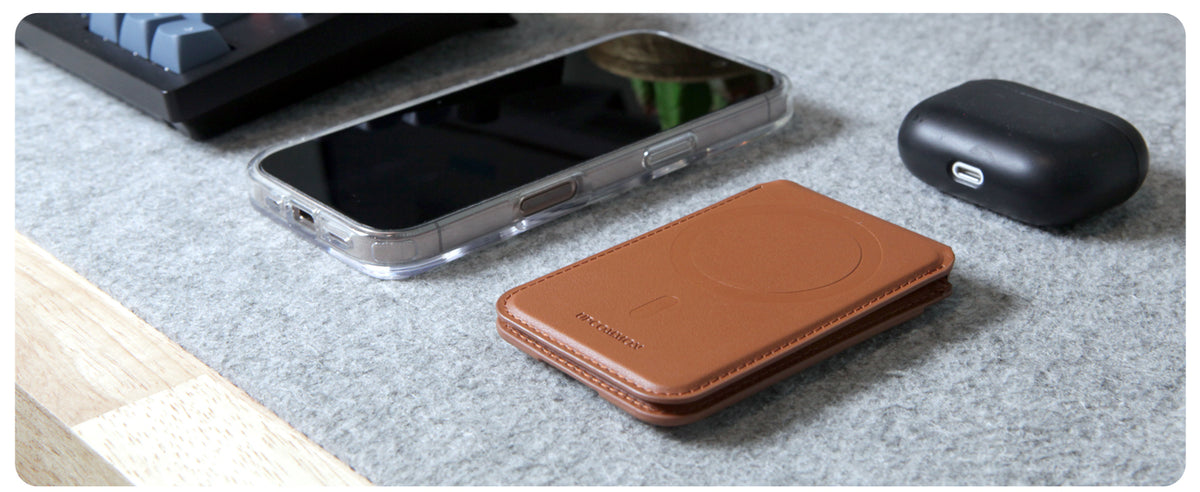 Saddle Tan Enclave wallet beside an iPhone and earbuds case